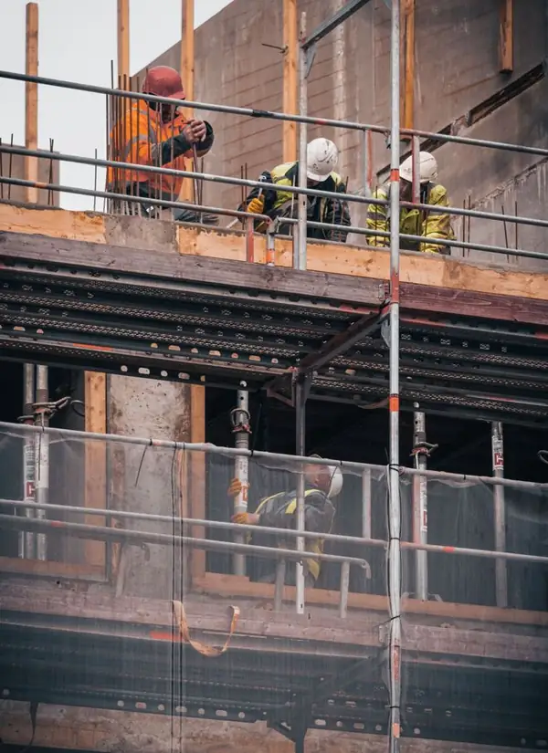 Workers on scaffolding at a concrete building site