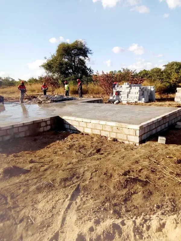 Workers finishing a freshly cast concrete floor slab