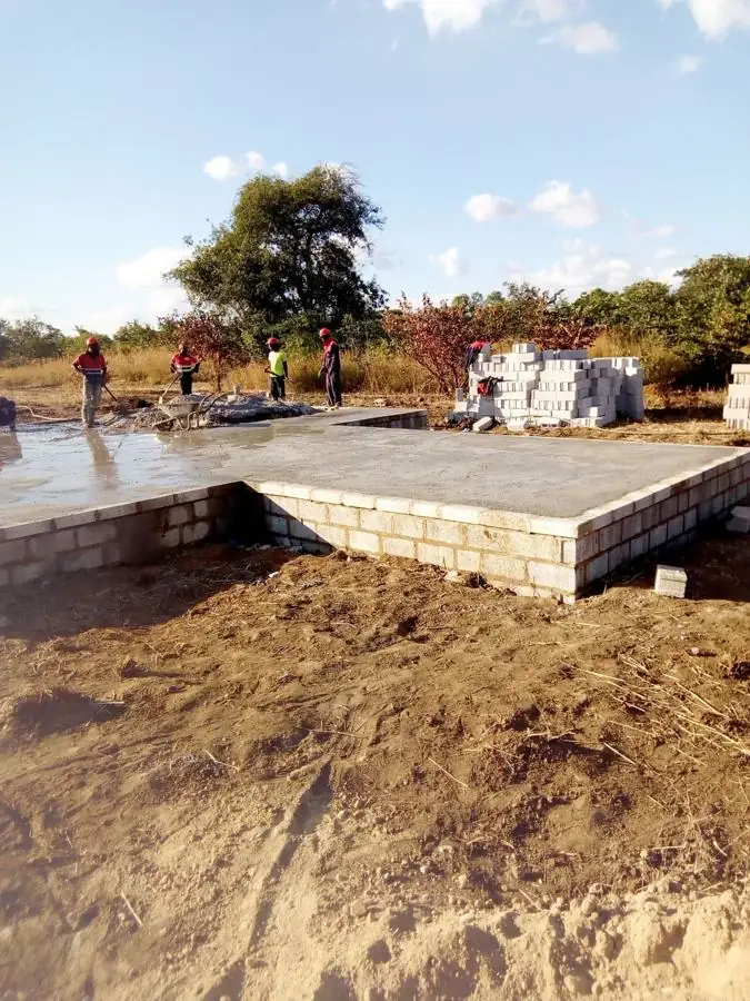 Workers finishing a freshly cast concrete floor slab