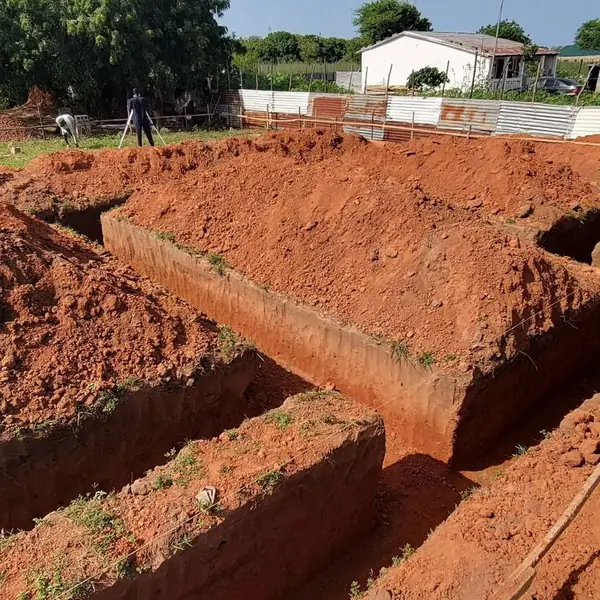 Excavated foundation trenches on a red-soil site